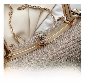 Macro view of champagne sequin evening clutch with rhinestone-studded spherical clasp