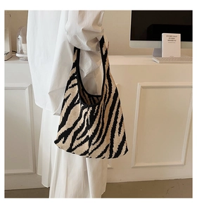 Borsa tote in maglia con motivo zebrato mostrata come borsa a spalla alla moda