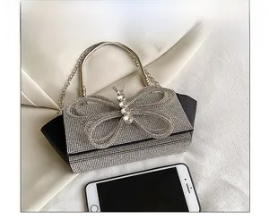 Detailed comparison of sparkling rhinestone evening bag next to smartphone for scale