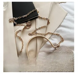 Detail of champagne gold sequin evening clutch with metal handle and chain strap
