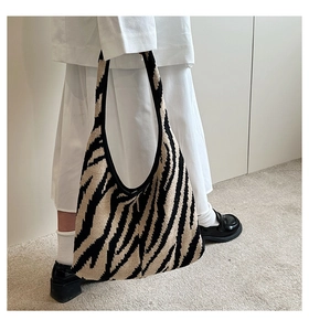 Dettaglio della trama a maglia e del motivo zebrato su questa borsa hobo alla moda