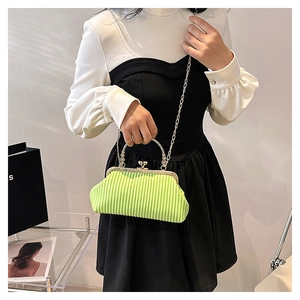 Detail of neon green pleated handbag featuring vintage gold frame and chain strap