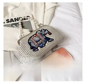 Detail of beaded elephant evening bag with pearl handle and metal chain for scale