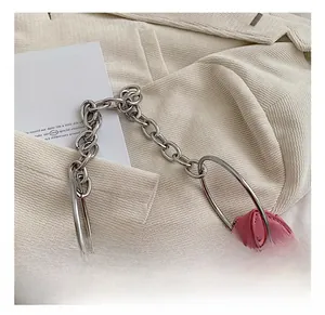 Détail du sac coeur en cuir rose avec chaîne argentée et poignée en anneau métal