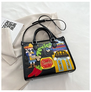 Détail du sac cabas noir à motif crocodile avec broderies colorées de style mexicain