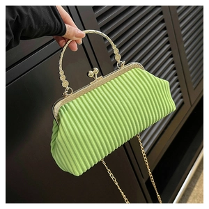 Detailed view of green pleated clutch with vintage gold handle and metallic chain strap