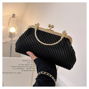 Detail of black pleated evening bag featuring vintage gold embossed frame and ball clasp