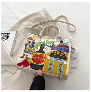 Détail de broderie mexicaine et patch tequila sur sac crème à motif crocodile