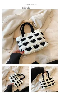 Viste dettagliate di una borsa all'uncinetto bianca e nera con cuori intrecciati