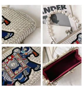Detail of beaded pearl handle and intricate crystal elephant embroidery on evening bag