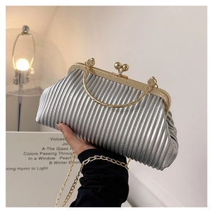 Close-up of silver pleated clutch bag with gold ball clasp and retro metal handle