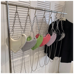 Détail de sacs à bandoulière en forme de cœur en plusieurs couleurs avec chaînes argentées