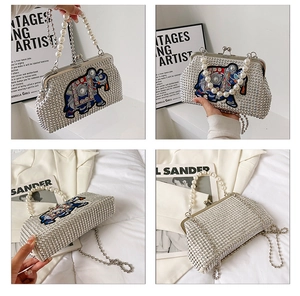 Detail view of crystal evening bag with embroidered elephant and pearl handle