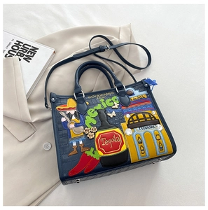 Détails de broderie mexicaine et motif crocodile sur sac à main en cuir bleu marine