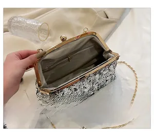 Detail of silver sequin evening clutch showing inner compartment and chain strap