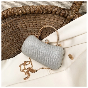 Close-up of silver glitter evening clutch with rhinestone gold handle and chain strap