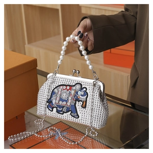 Detailed shot of ethnic elephant embroidery and silver rhinestones on luxury evening bag