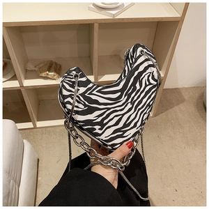 Détail du sac en forme de cœur à motif zèbre avec chaîne argentée et boucle en métal