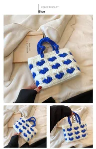 Dettaglio della borsa a mano in maglia fatta a mano con cuori blu e manici intrecciati