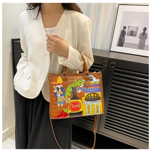 Détails de broderie mexicaine et graffitis colorés sur un sac cabas en cuir marron