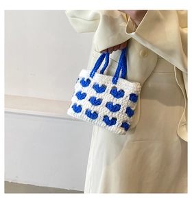 Dettaglio della borsa crochet con motivi a cuore blu e trama a maglia fatta a mano