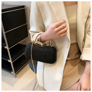 Detail of elegant black sequin evening clutch with gold metal handle and crystal clasp