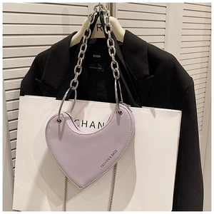 Vue détaillée du sac coeur lilas avec grosse chaîne argentée et logo imprimé