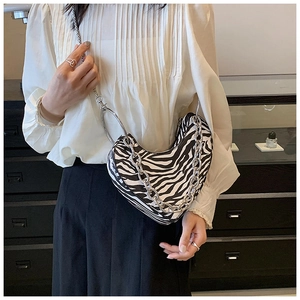 Détail du sac à main cœur à motif zébré avec chaîne argentée et poignée en anneau