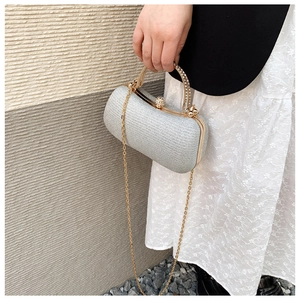 Detail of silver glitter clutch bag with gold rhinestone handle and chain strap