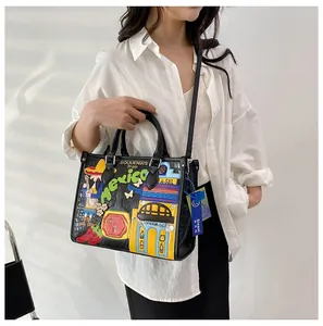 Détail de broderie mexicaine et patchs colorés sur sac noir en cuir de crocodile gaufré