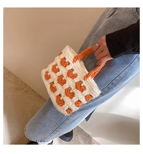 Dettaglio mini borsa tote lavorata a mano con trama all'uncinetto arancione e bianca