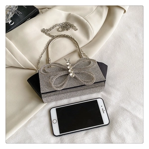 Detailed close-up of a luxury rhinestone butterfly evening bag with shiny metallic handle
