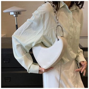 Détail du sac à bandoulière blanc en forme de cœur avec grosse chaîne argentée et texte