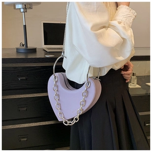 Détail du sac à main lavande en forme de cœur avec chaîne argentée et poignée en métal
