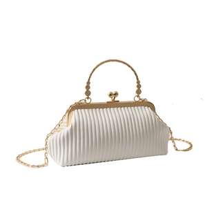 White pleated evening bag with gold metal handle and chain strap on white background