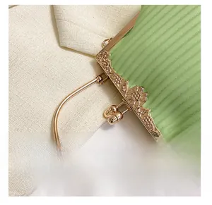 Detail of light green pleated handbag with vintage floral engraved gold metal frame