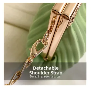 Detail view of mint green pleated evening bag with gold clasp and detachable chain strap