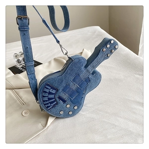 Détail du sac bandoulière en denim bleu en forme de guitare avec broderie et rivets en métal