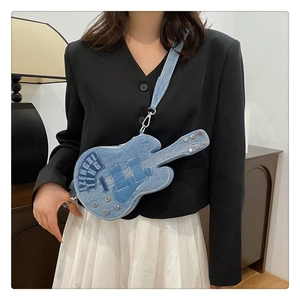 Détail du sac bandoulière en denim en forme de guitare avec tissu bleu délavé et broderie