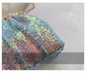 Macro detail of holographic sequins and floral rhinestone clasp on evening clutch