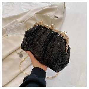 Detail of black sequined clutch with flower diamond buckle and gold chain strap