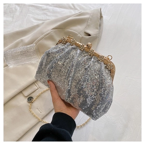 Detail of silver sequin evening clutch bag with pearl trim and golden metal clasp