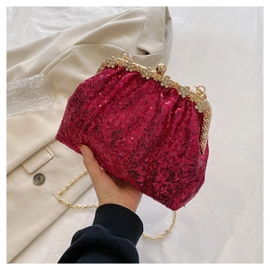 Macro detail of wine red sequin clutch with golden vintage frame and crystal buckle