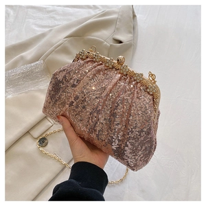 Macro detail of rose gold sequin evening bag with sparkling rhinestone floral clasp