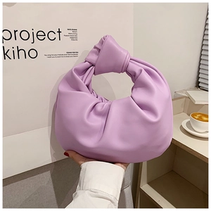 Close-up of lavender pleated leather handbag featuring a stylish knotted handle detail