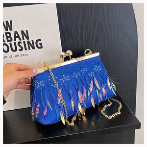 Detail of royal blue evening bag with sequins, lace embroidery, and iridescent leaf tassels