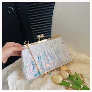 Detail of white lace clutch with colorful iridescent tassels and pearl clasp closure