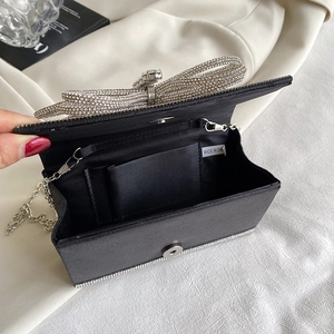 Elegant black satin evening clutch bag with a large sparkling rhinestone bow and chain