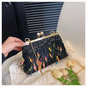 Detail of evening bag with black sequins, laser tassels, pearl clasp and gold chain