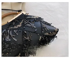 Detailed macro view of black fabric with black and gold sequin diamond embroidery and clasp